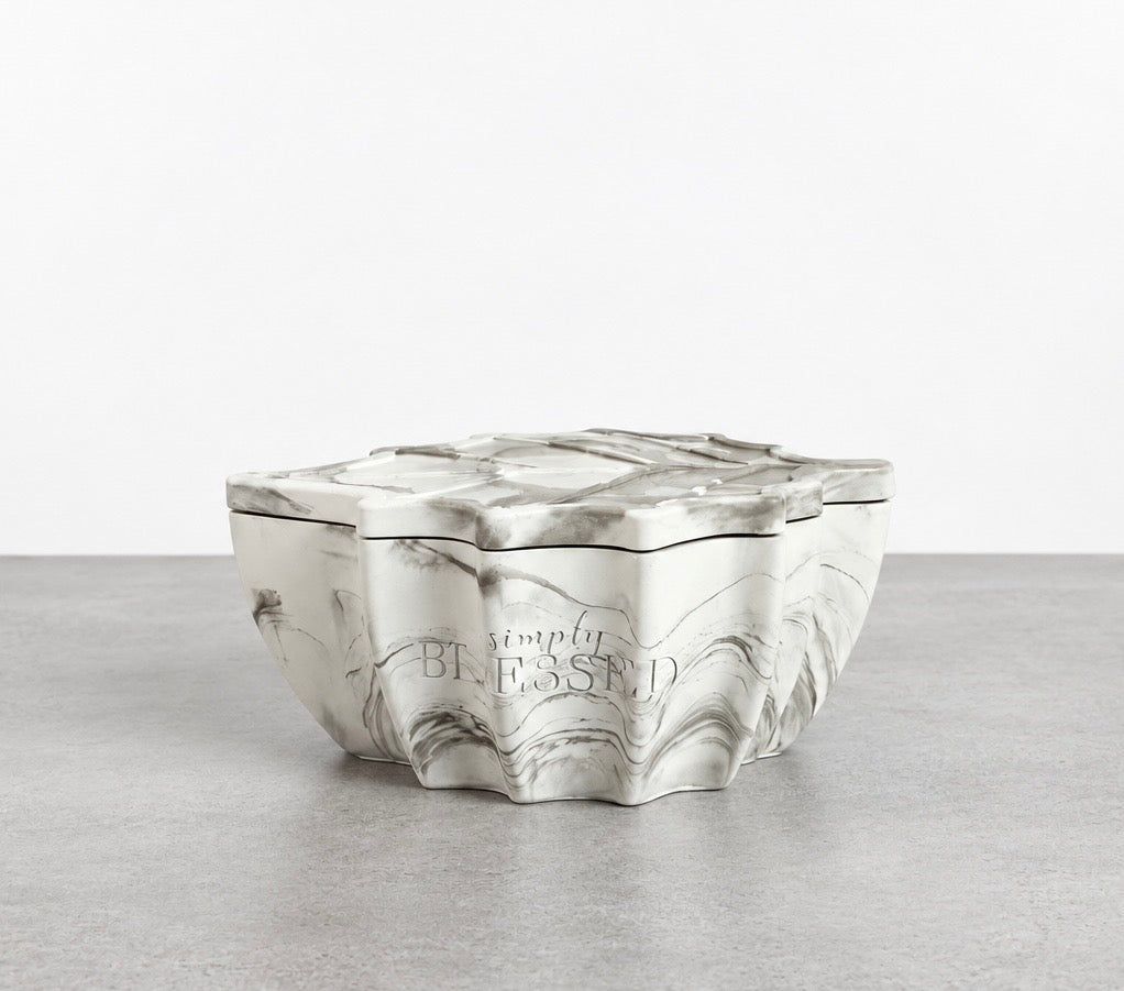 Closed Simply Blessed leaf candle in a white and green marbled concrete vessel with a matching leaf-shaped lid.