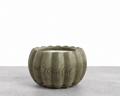 Handcrafted pumpkin-shaped concrete candle in muted olive green, with ‘Thankful’ engraved on the front, photographed against a white backdrop.