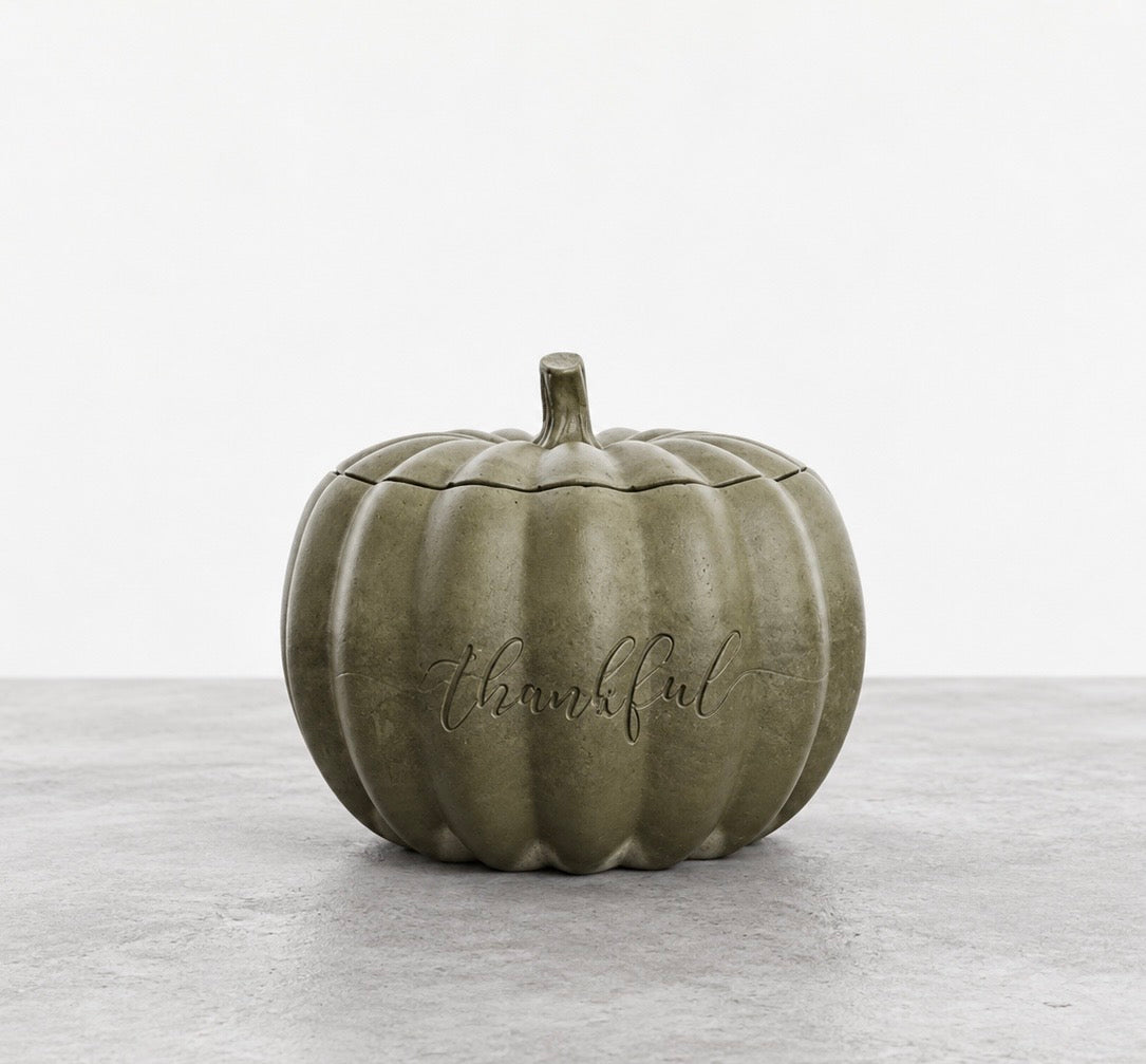 Closed Thankful pumpkin candle in smoky olive green concrete, with an engraved front and a matching ribbed lid topped with a stem.