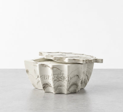 White and green marbled Simply Blessed leaf-shaped concrete candle vessel with its matching lid resting on top.