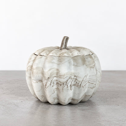Thankful pumpkin candle in a marbled concrete vessel with its stemmed lid in place and engraved lettering on the front.