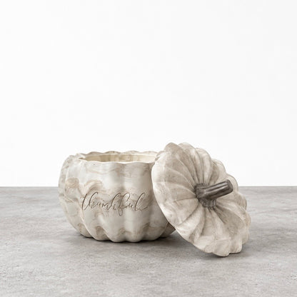 Open Thankful pumpkin candle in a marbled concrete vessel, with its matching stemmed lid leaning against the front.