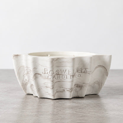 Back view of the white and green marbled leaf concrete candle, showing the Boswellia Candle Co. engraving and three unlit wicks.