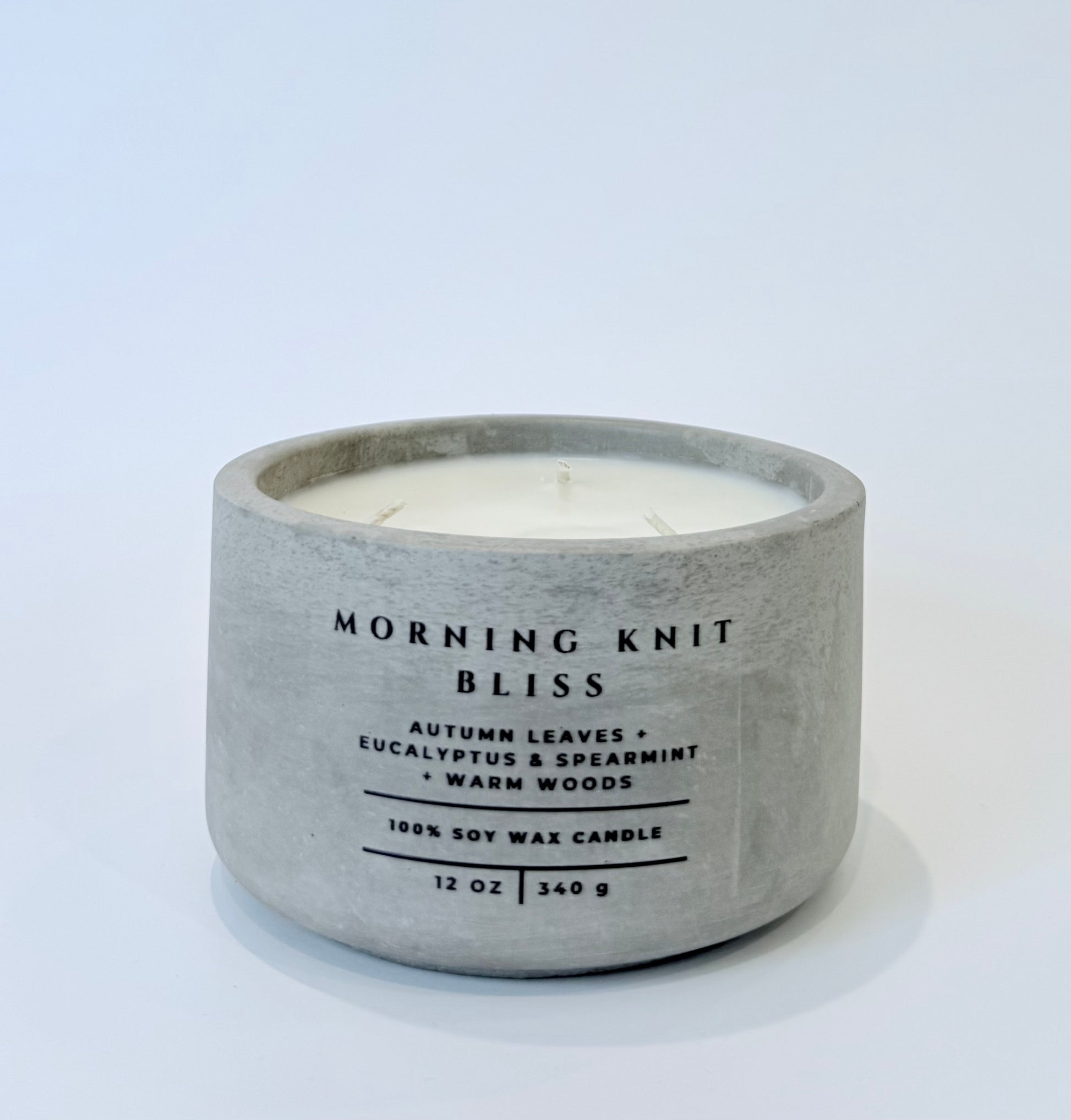 Morning Knit Bliss soy candle in gray concrete vessel on white background