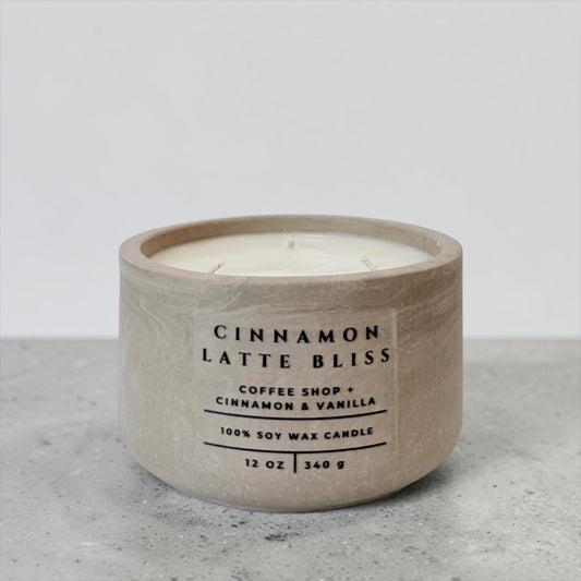 Cinnamon Latte Bliss soy candle in beige concrete vessel with coffee, cinnamon and vanilla scent on gray background