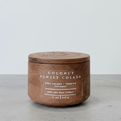 Coconut Sunset Colada Scripture Candle featuring Proverbs 16:3, a 12 oz soy wax candle in a handcrafted concrete vessel with tropical piña colada and toasted coconut notes.