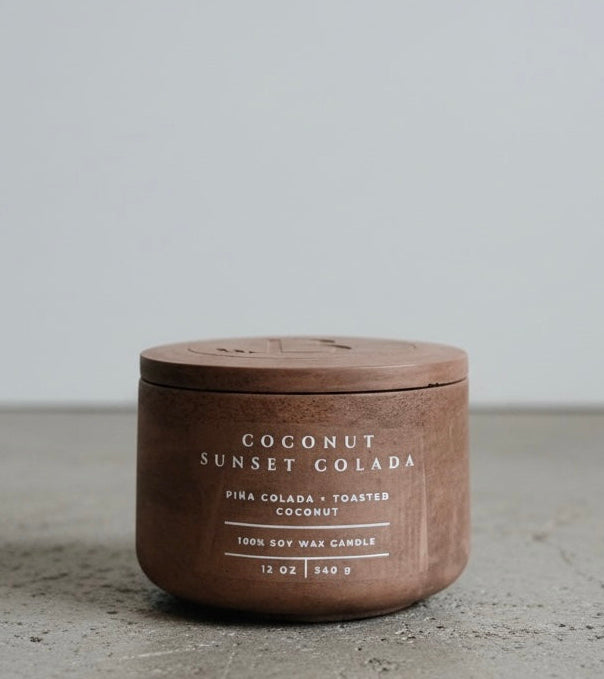 Coconut Sunset Colada Scripture Candle featuring Proverbs 16:3, a 12 oz soy wax candle in a handcrafted concrete vessel with tropical piña colada and toasted coconut notes.