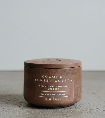 Coconut Sunset Colada Scripture Candle featuring Proverbs 16:3, a 12 oz soy wax candle in a handcrafted concrete vessel with tropical piña colada and toasted coconut notes.
