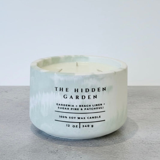 The Hidden Garden Christian Soy Candle with Gardenia, Beach Linen, Sugar Pine, and Patchouli in a Handcrafted Concrete Vessel.